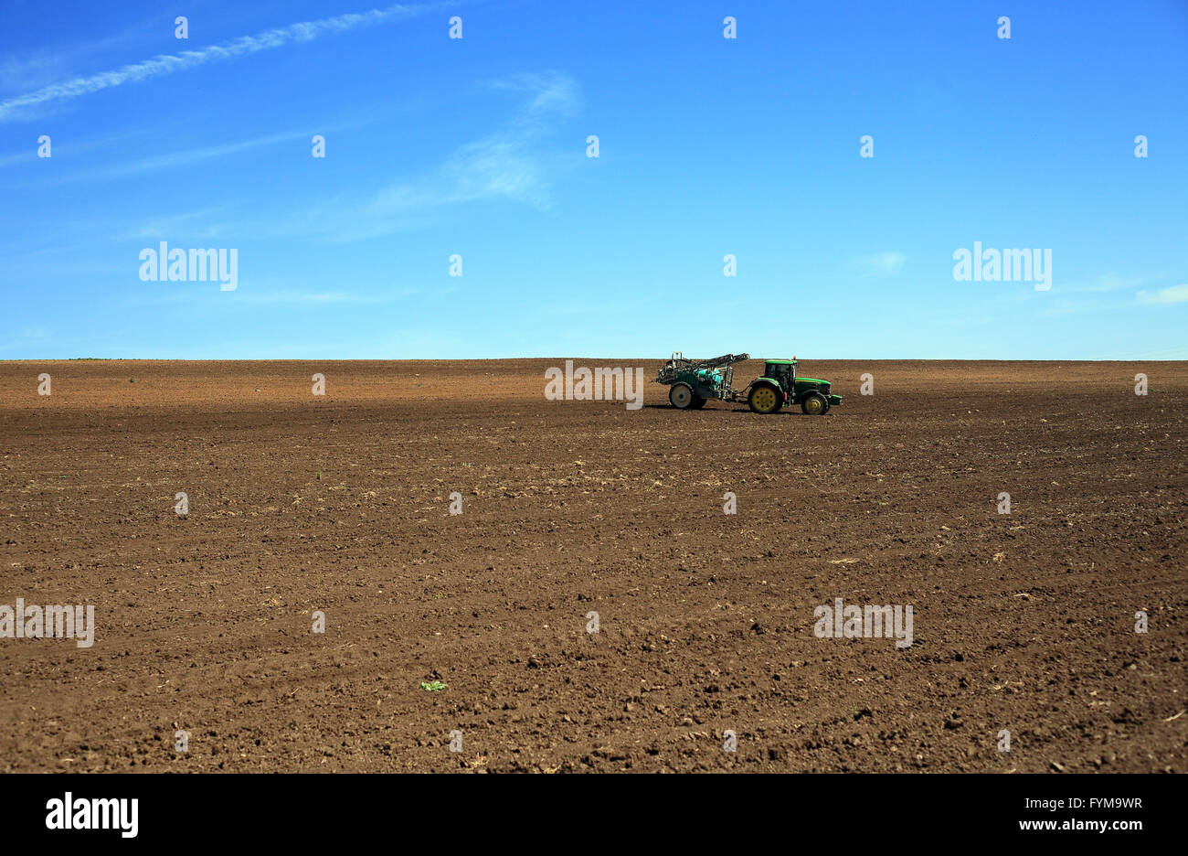 Paesaggio di primavera nella pianura del Danubio in Bulgaria. Il trattore lavorano la terra. Foto Stock