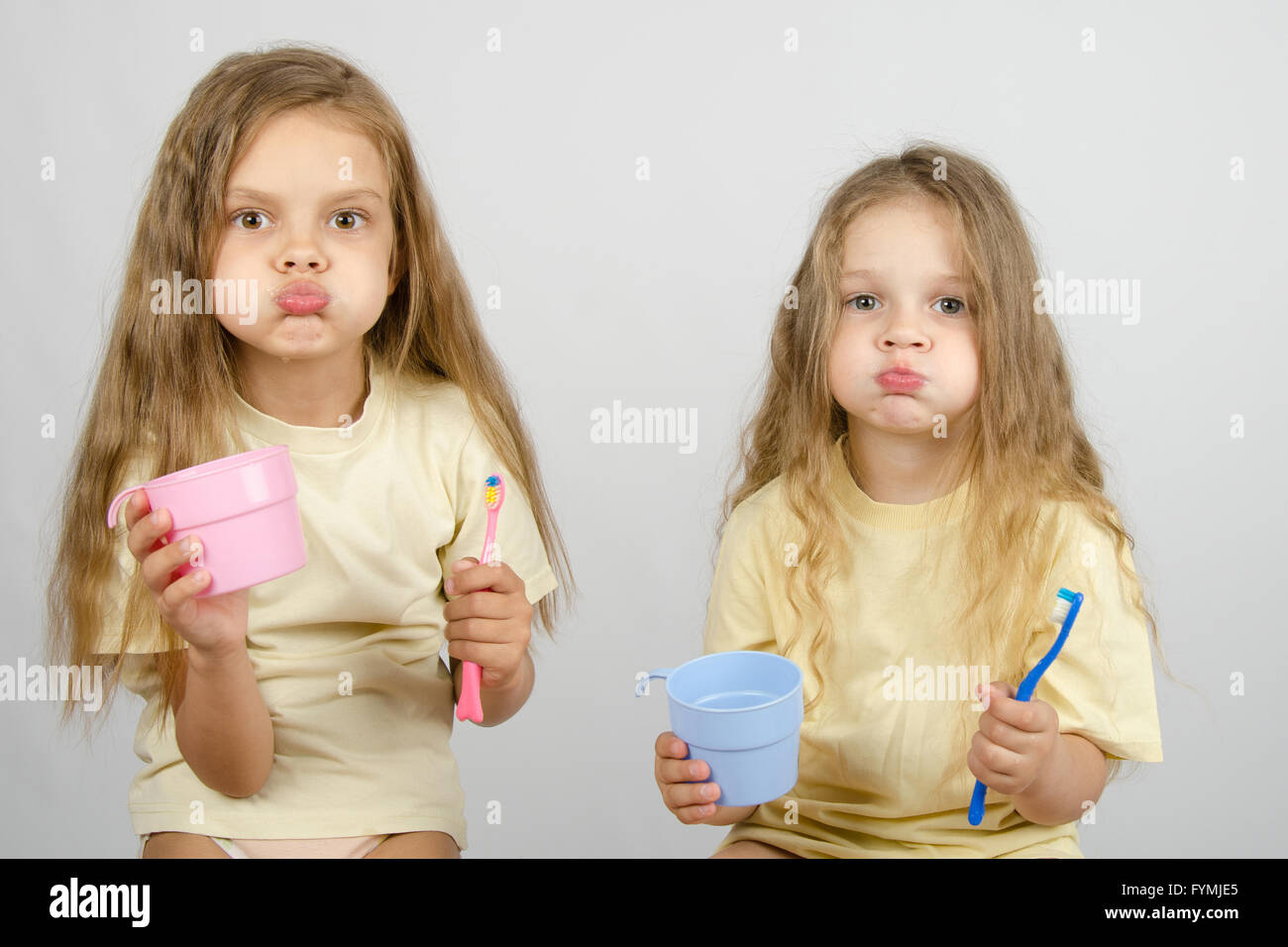 Due sorelle sciacquare la bocca lavarsi i denti Foto Stock