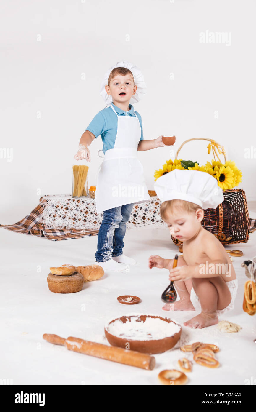 Bambina e ragazzo divertente indossando cappelli dello chef Foto Stock