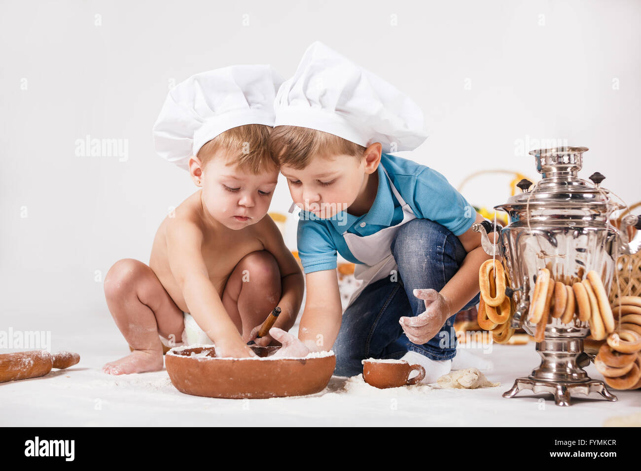 Bambina e ragazzo divertente indossando cappelli dello chef Foto Stock