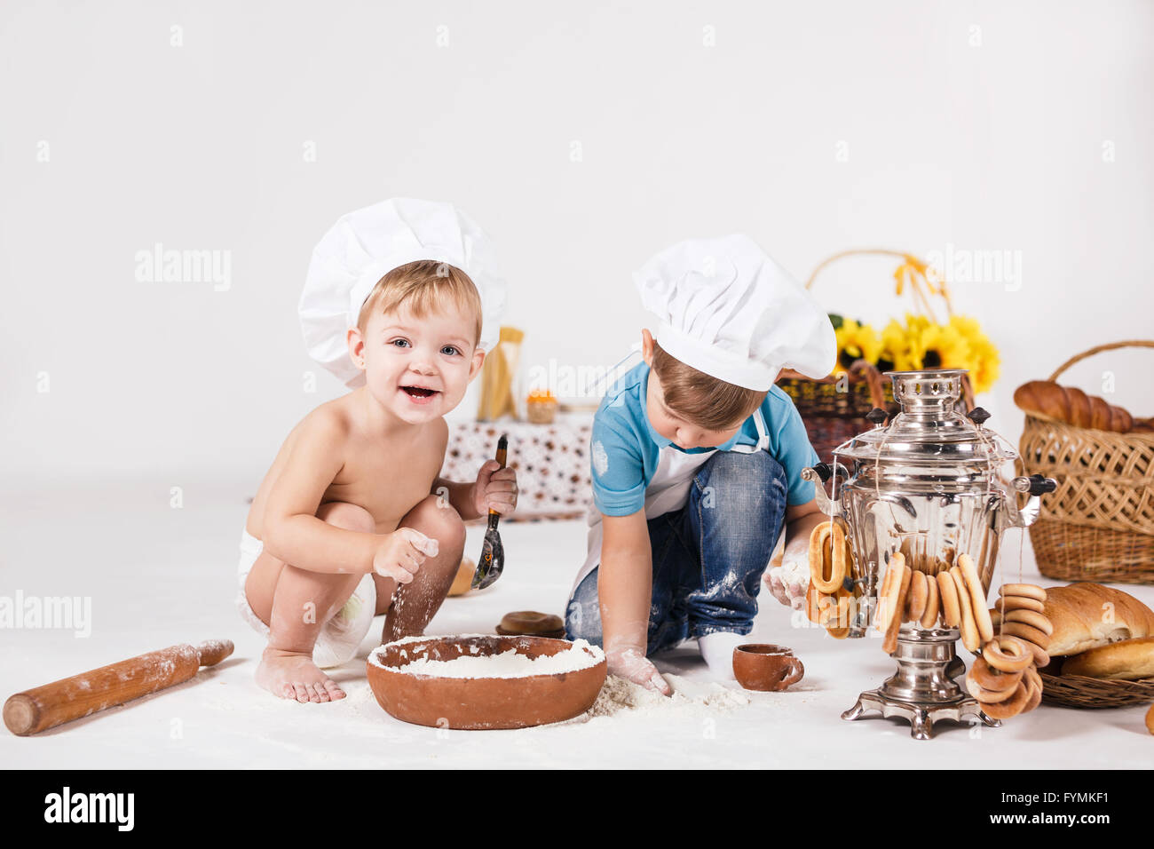 Bambina e ragazzo divertente indossando cappelli dello chef Foto Stock