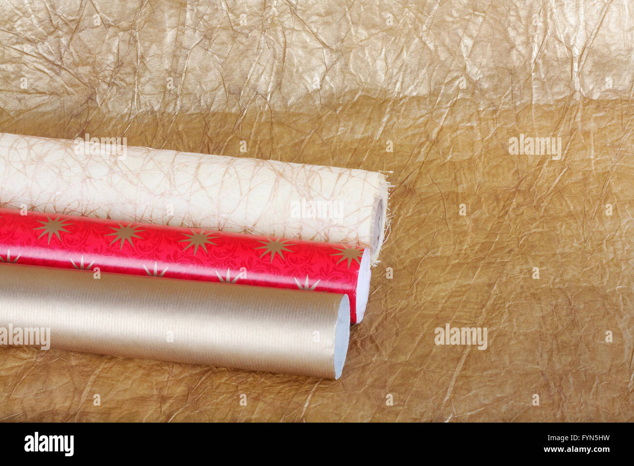 Rotoli di variopinte carta di avvolgimento per doni oro su sfondo astratto. Foto Stock