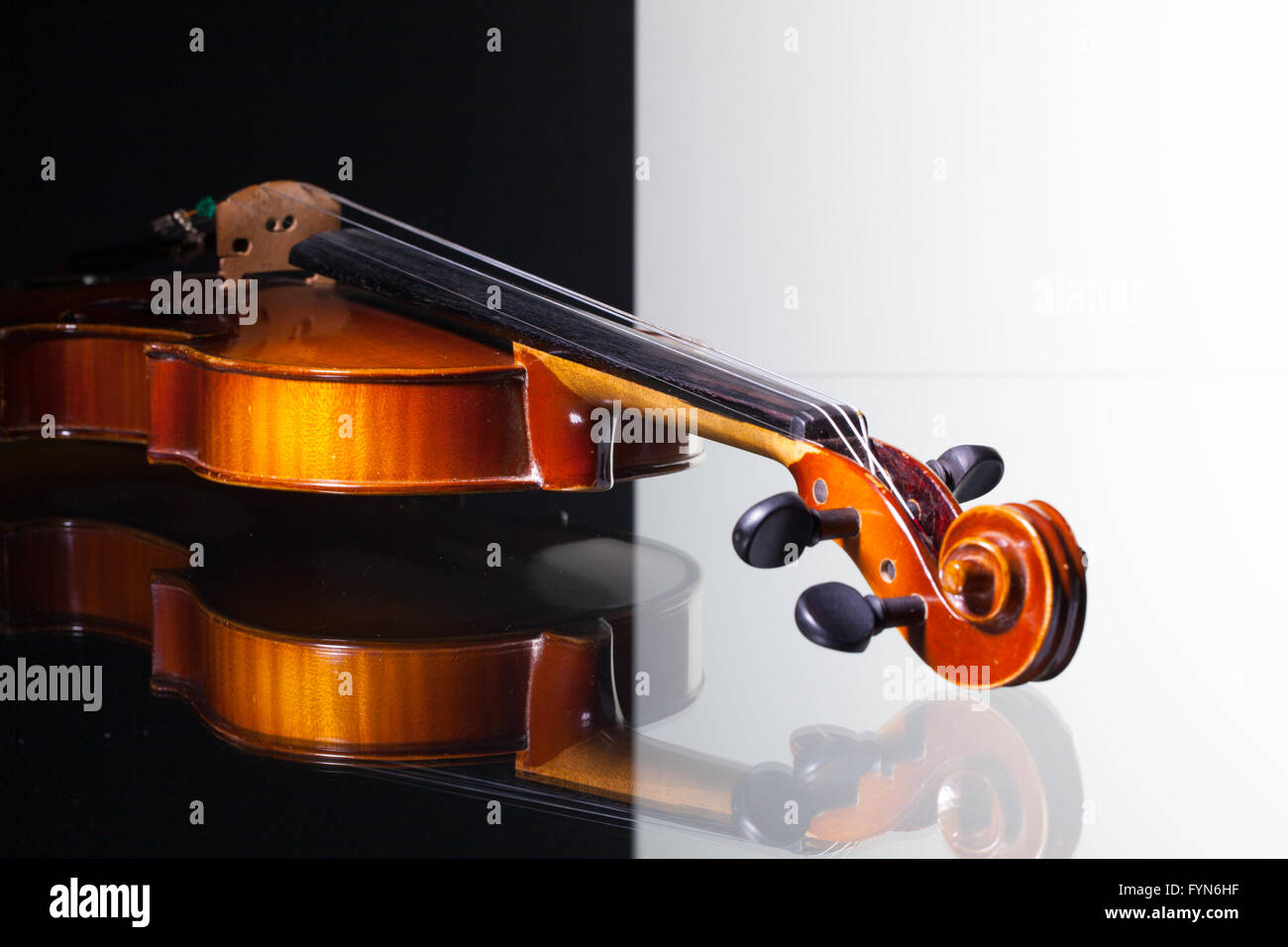 Vecchio violino isolato in bianco e nero e sfondo scrivania in vetro Foto Stock