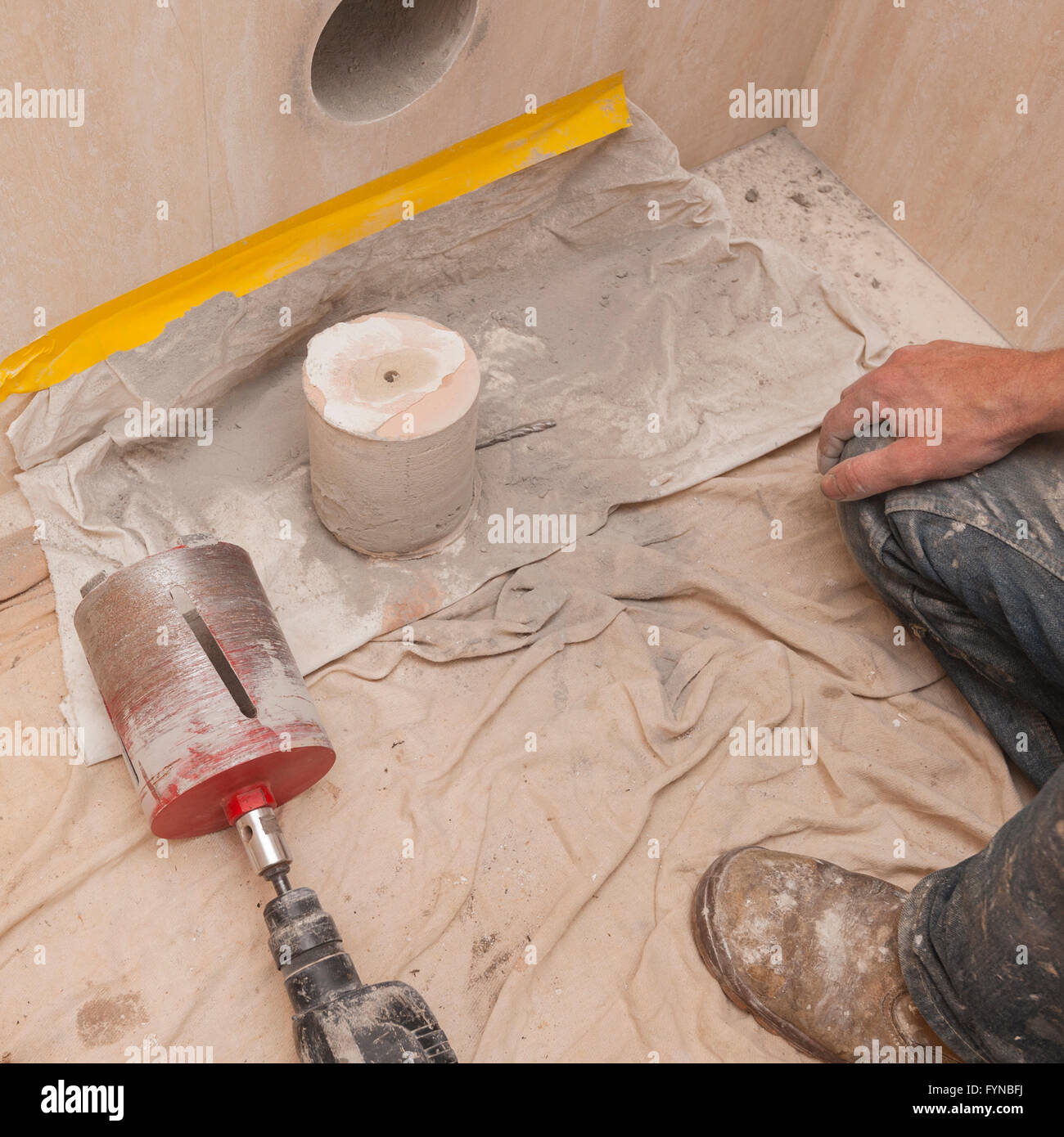 Un costruttore di trapani un foro attraverso parete per un 4 pollice tubo di suolo che mostra il nucleo nel Regno Unito Foto Stock