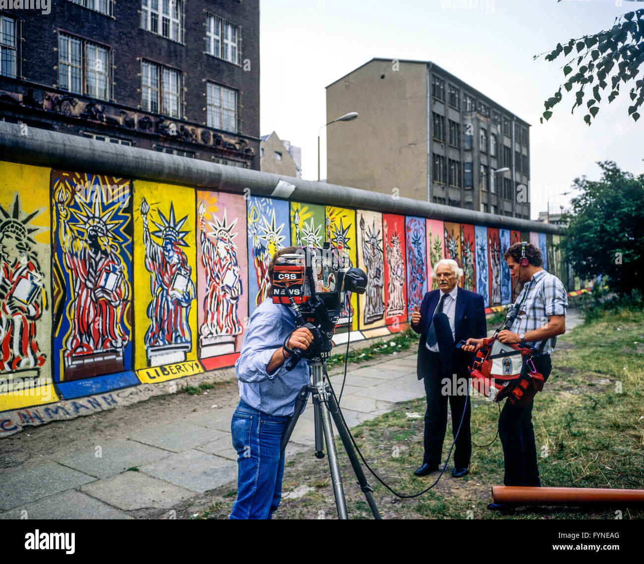 Agosto 1986, CBS TV equipaggio condurre un colloquio davanti al muro di Berlino decorate con Statua della Libertà affreschi, Berlino Ovest lato, Germania, Europa Foto Stock