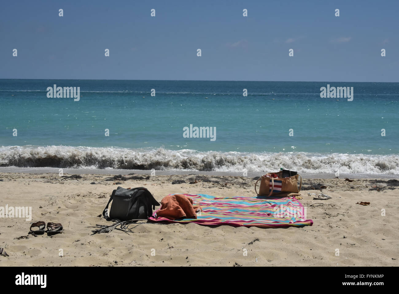 Una coperta di sandali, asciugamani e due sacchi su una spiaggia deserta con il mare sullo sfondo. Sun Bay, Vieques, Puerto Rico Foto Stock