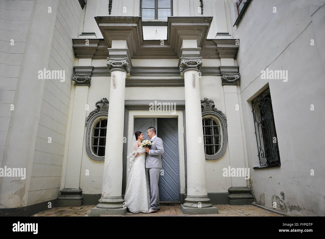 Coppie in viaggio di nozze nei pressi di antiche colonne di pietra Foto Stock