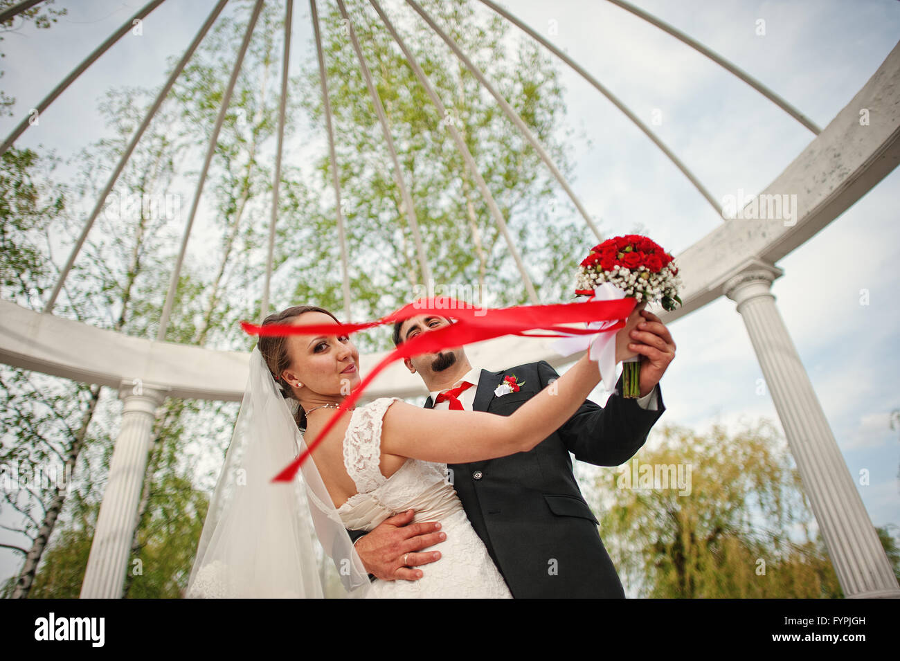 Coppie in viaggio di nozze al di sotto dell'arco Foto Stock