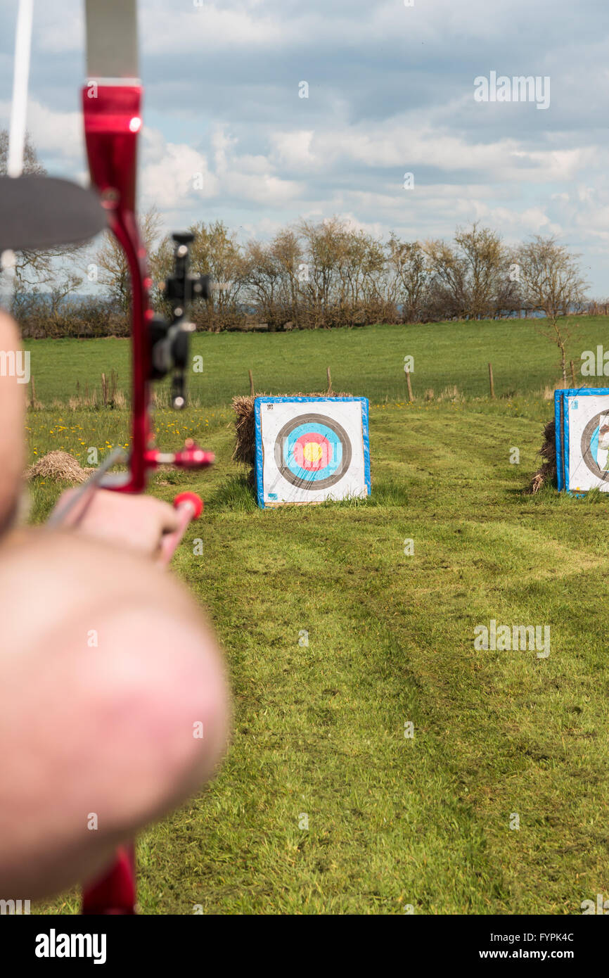 Archer praticare il tiro con l arco di campo preparazione per perdere la sua freccia sul bersaglio Foto Stock
