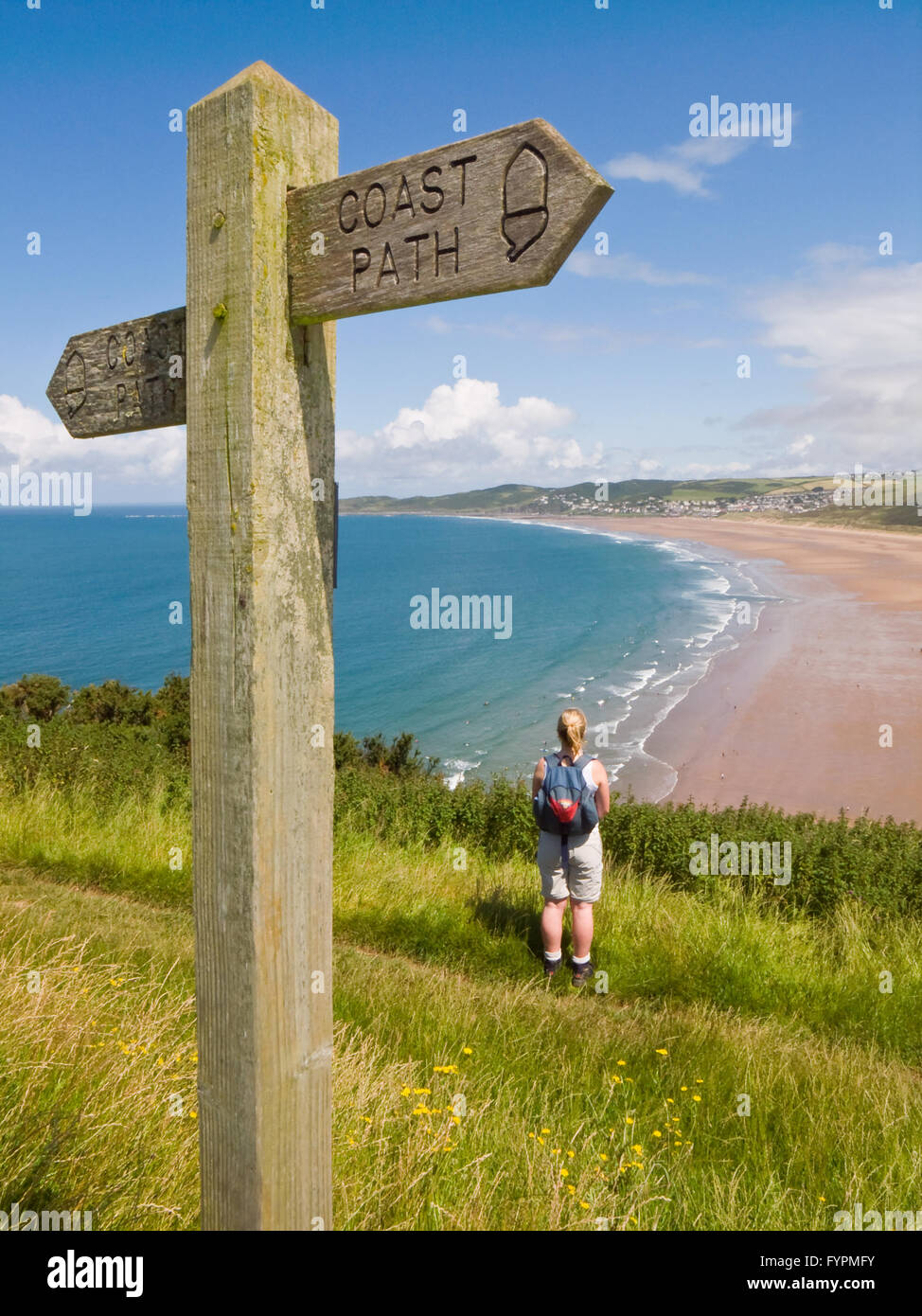 Un viandante sul sentiero costiero si affaccia su Woolacombe Beach nel Devon, in Inghilterra. Foto Stock