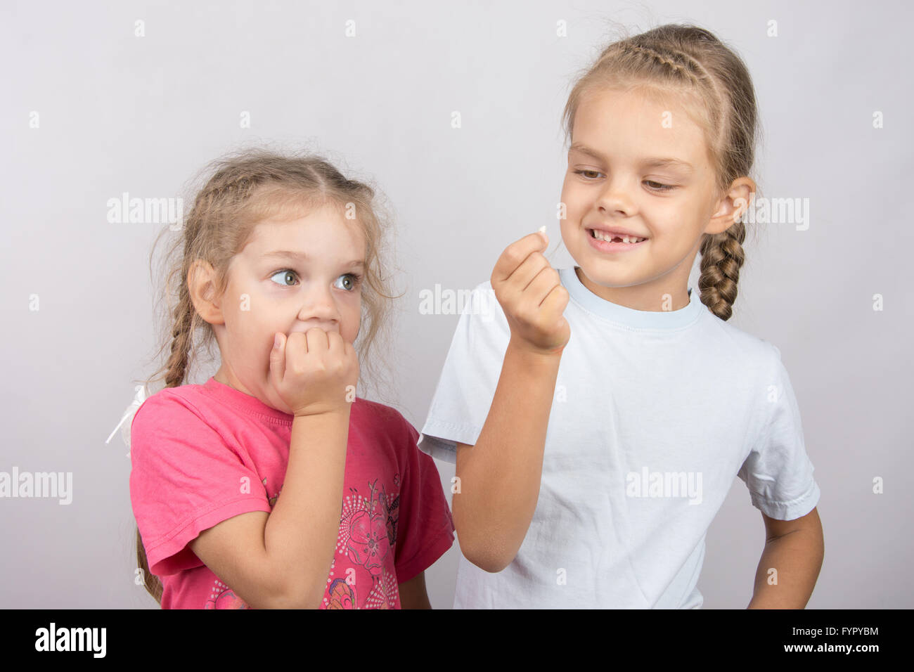 Quattro anni di ragazza con la paura di guardare il dente perduto nella sua mano a sei anni di ragazza Foto Stock