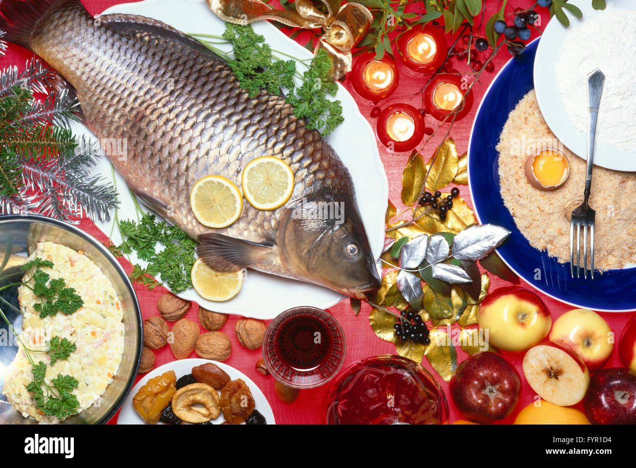 Impanato carpa natalizia con insalata di patate, ingredienti, decorazioni di Natale Foto Stock