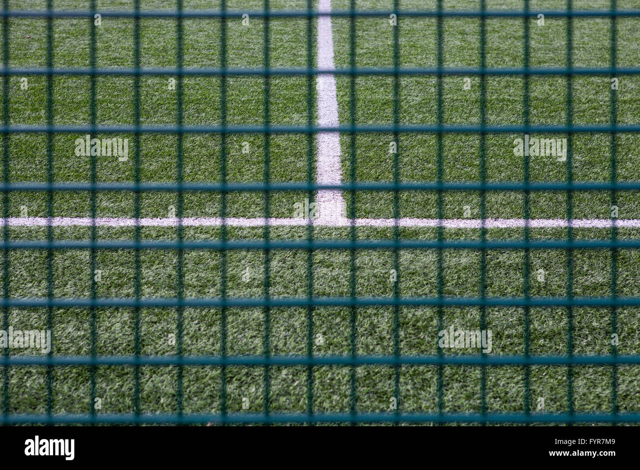 Per tutte le condizioni atmosferiche Campo da gioco con righe bianche dietro un recinto. Foto Stock