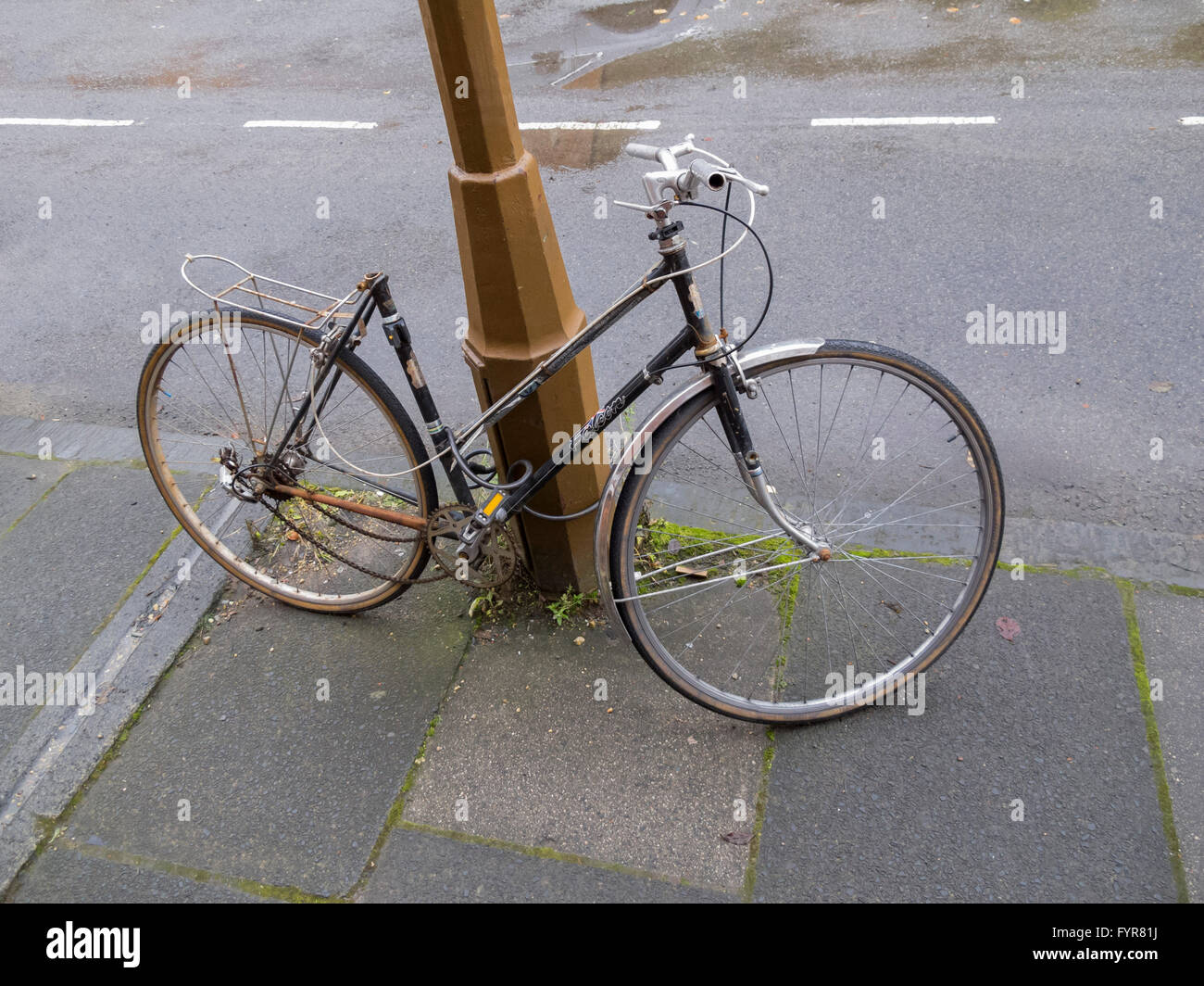 Una vecchia signora o di donna di bicicletta senza sella bloccato ad un  lampione Foto stock - Alamy