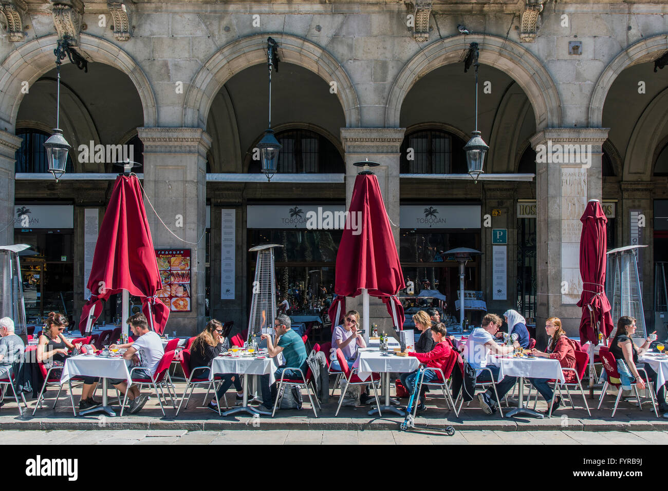 Outdoor cafe con i turisti seduti ai tavoli in Placa Reial o Plaza Real di Barcellona, in Catalogna, Spagna Foto Stock