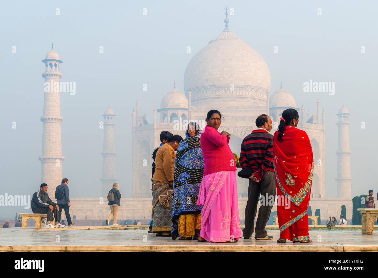 Gruppo di turisti indiani in abiti colorati in una nebbiosa mattina nella parte anteriore del Taj Mahal in Agra India Foto Stock Gruppo di turisti indiani in abiti colorati in una nebbiosa mattina nella parte anteriore del Taj Mahal in Agra India Foto Stock