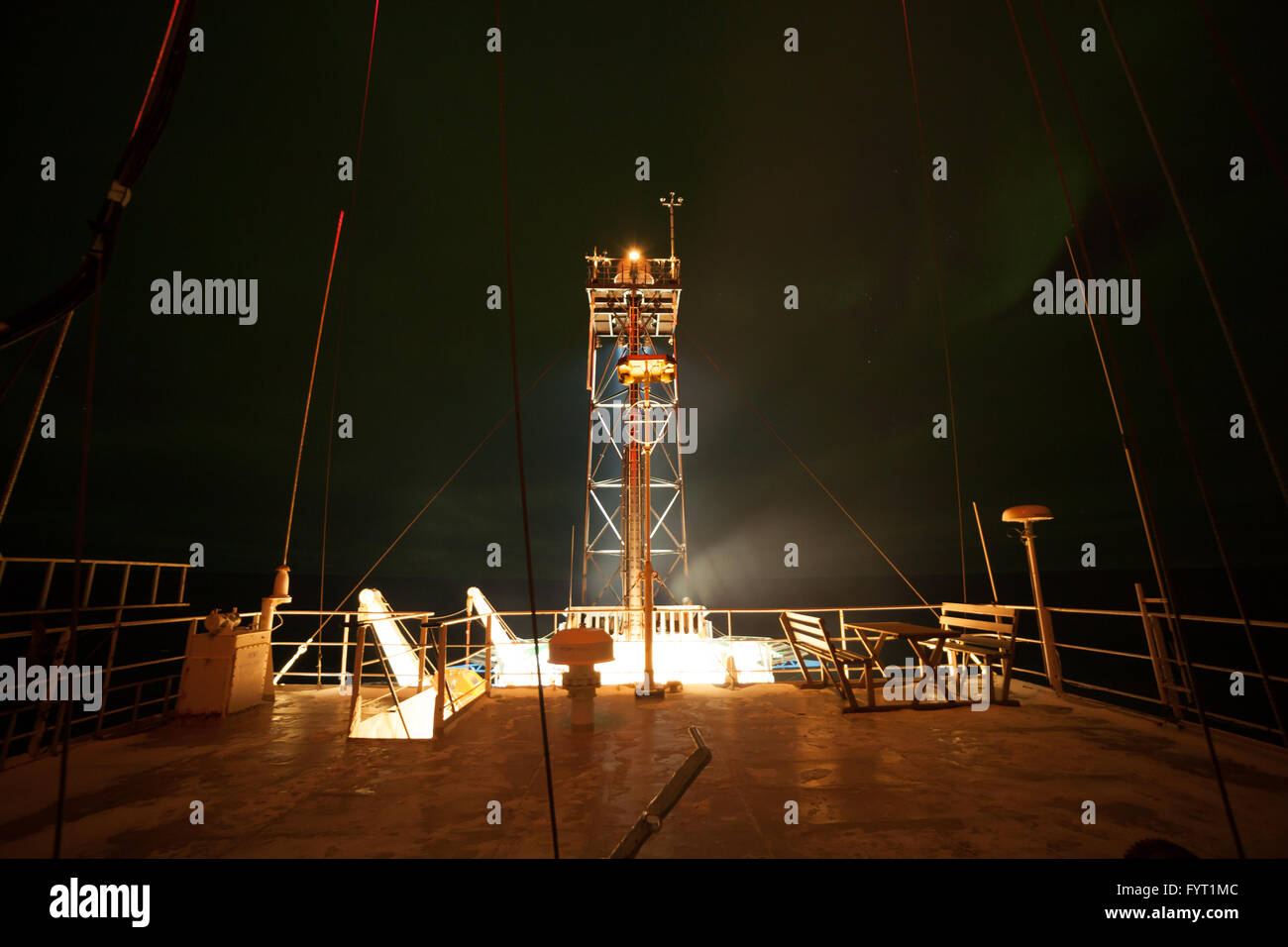 Vista notturna del ponte superiore della nave e l'aurora boreale debole Foto Stock