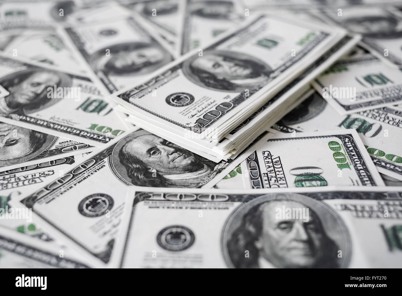 Una pila di denaro. Cumulo di banconote da cento dollari su sfondo di denaro. Denaro falso. Profondità di campo. Messa a fuoco selettiva. Foto Stock