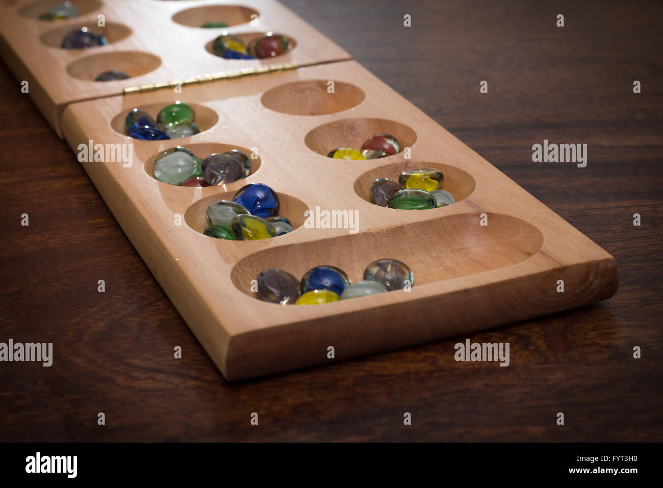 Mancala tradizionale tavolo con pezzi di vetro sul tavolo di legno Foto Stock