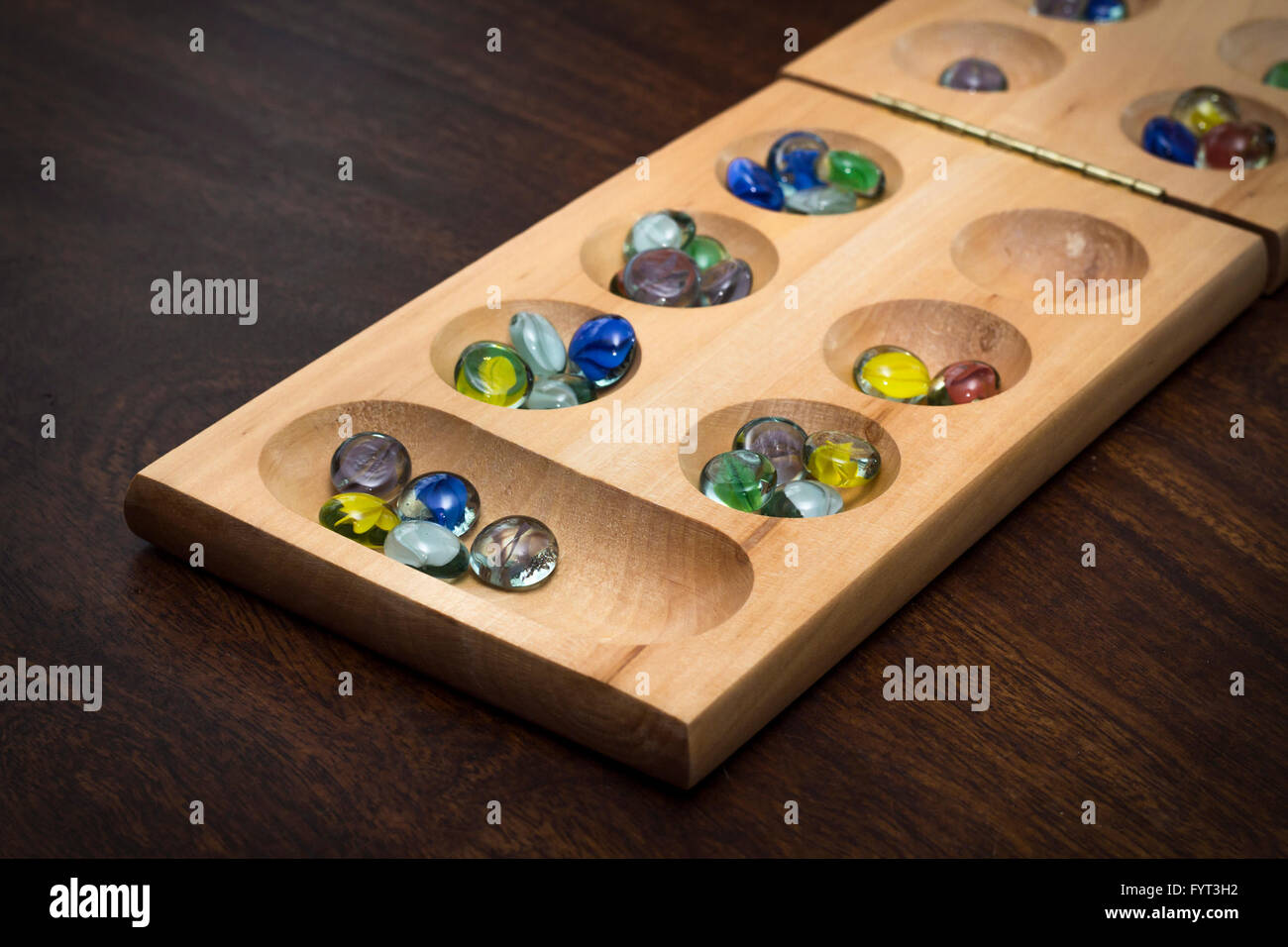 Mancala tradizionale tavolo con pezzi di vetro sul tavolo di legno Foto Stock