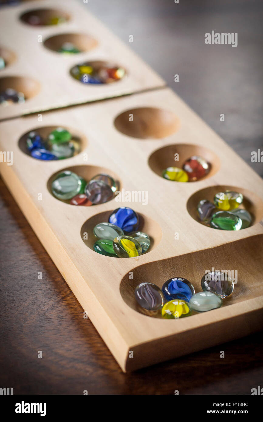 Mancala tradizionale tavolo con pezzi di vetro sul tavolo di legno Foto Stock
