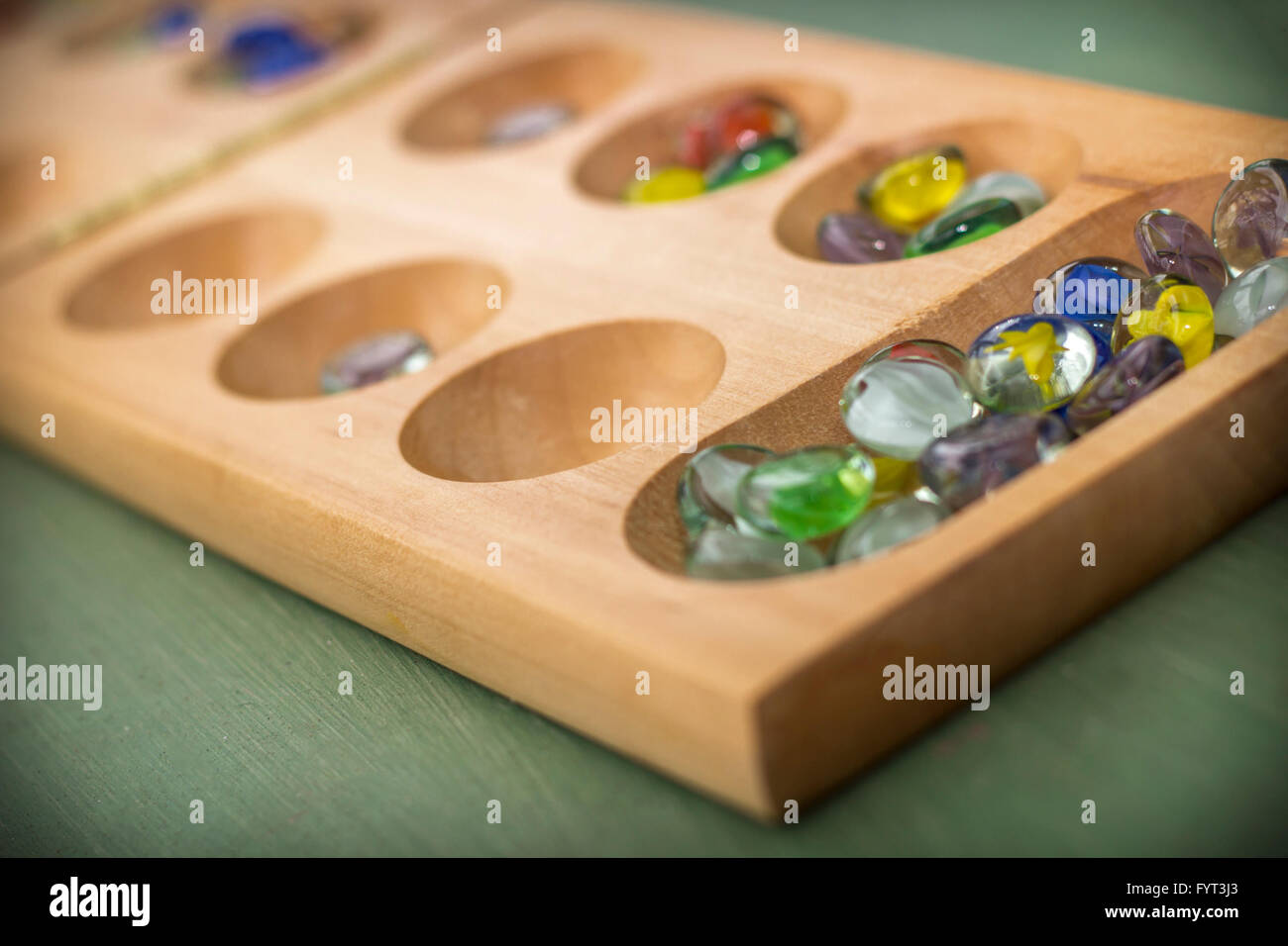 Mancala tradizionale tavolo con pezzi di vetro sul tavolo di legno Foto Stock