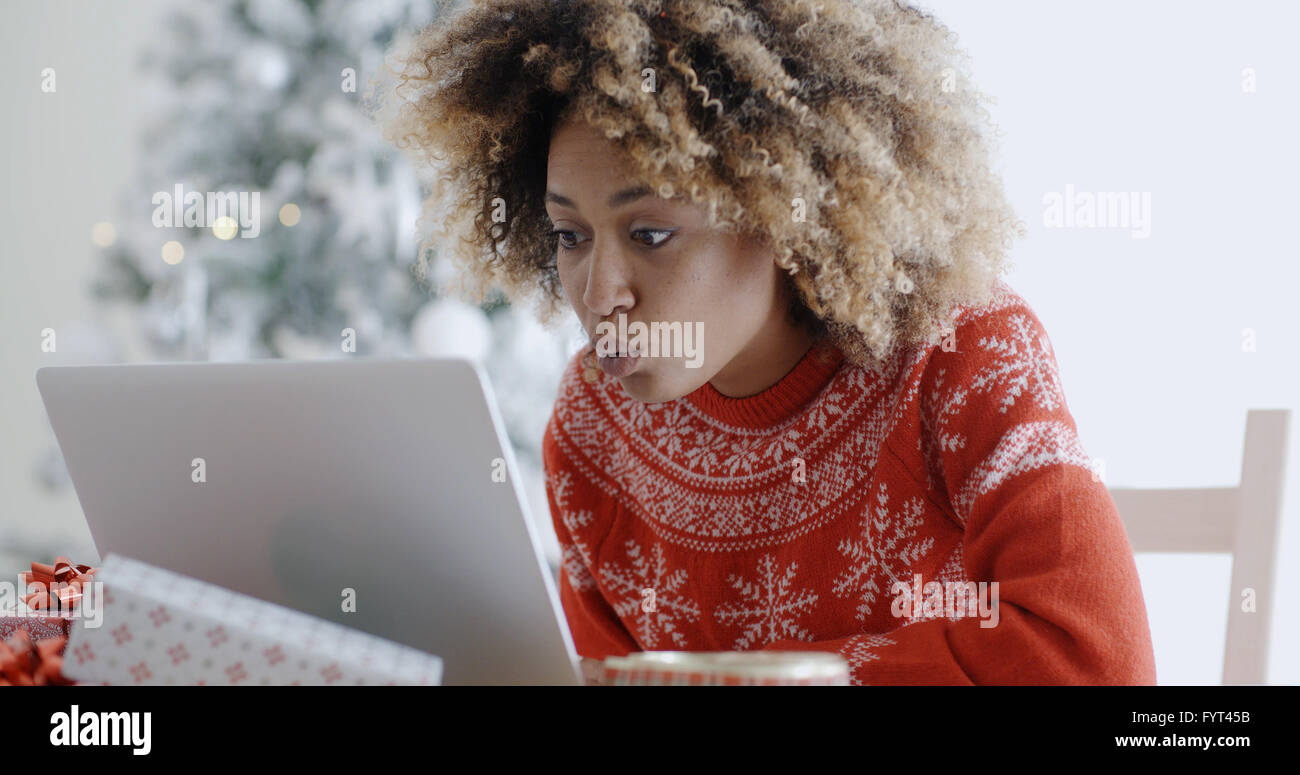 Excited donna shopping online per Natale occasioni Foto Stock