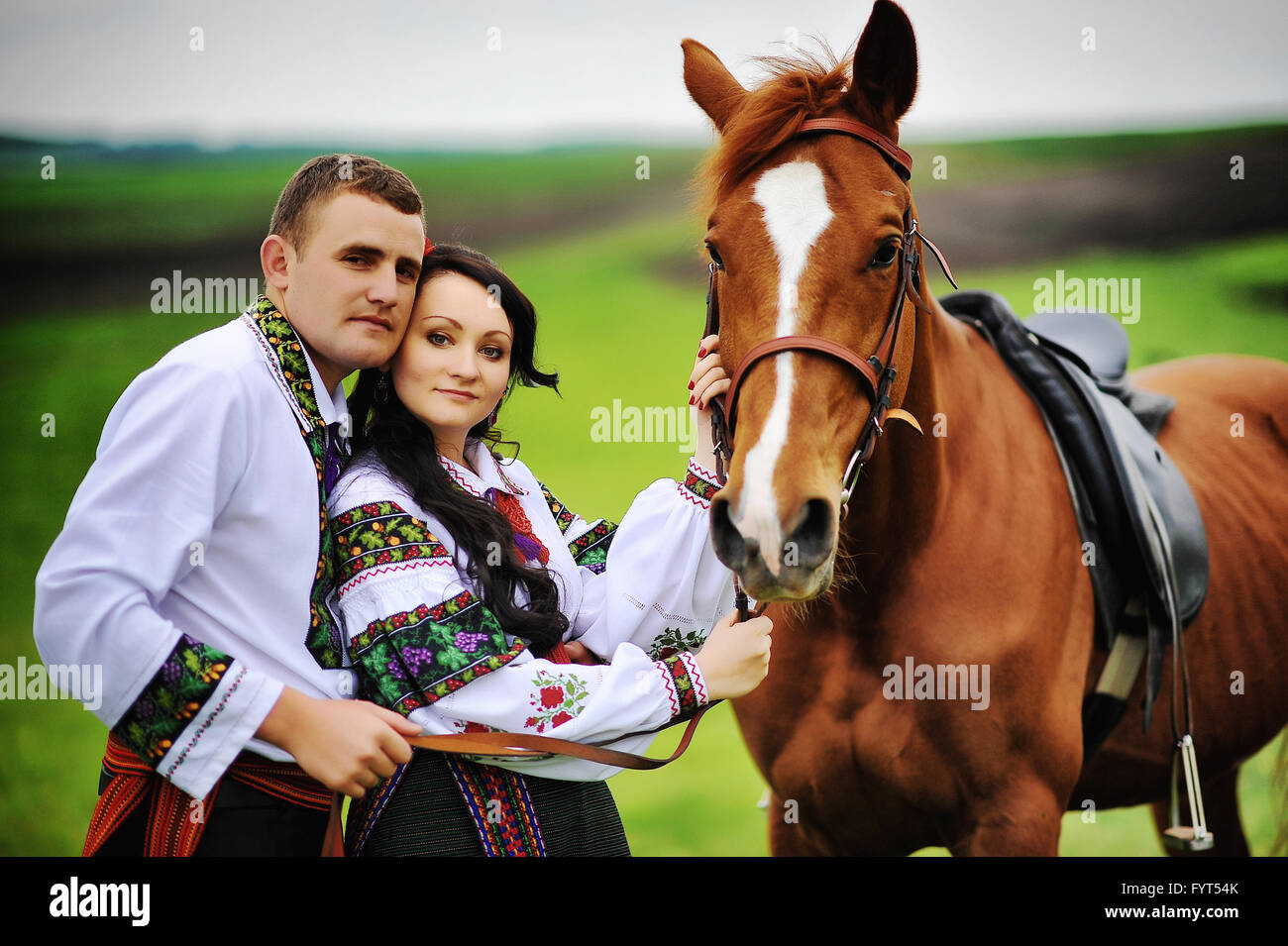 Una giovane coppia in abito nazionale con i cavalli Foto Stock