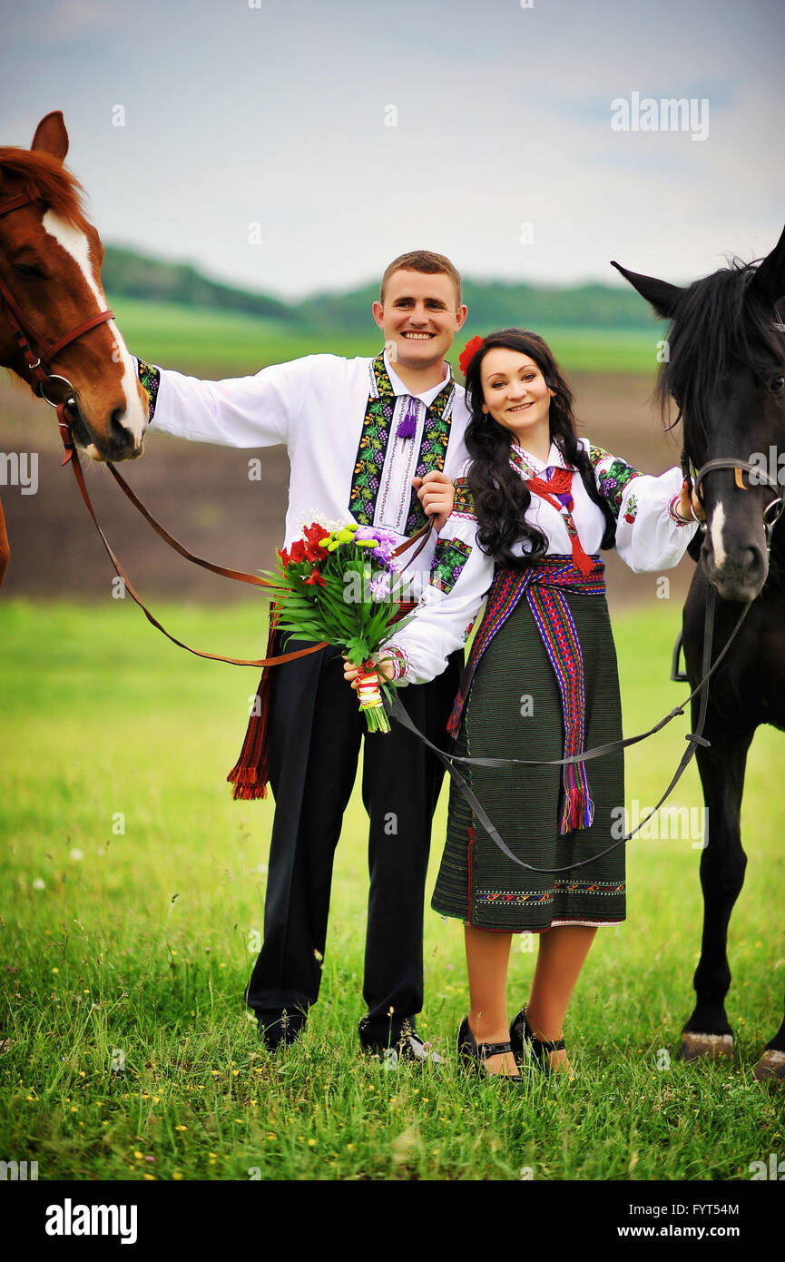 Una giovane coppia in abito nazionale con i cavalli Foto Stock