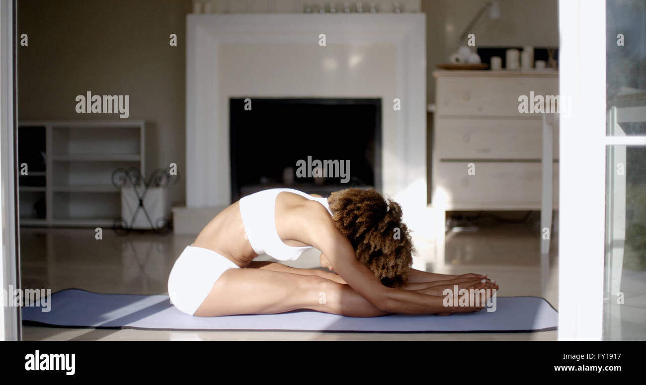 Giovane donna fare yoga a casa Foto Stock