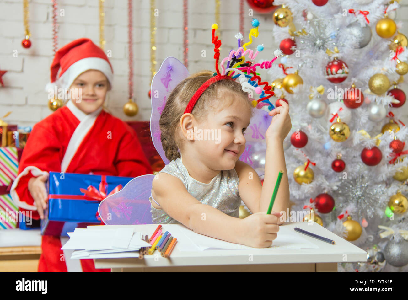 La ragazza prelevato un giocattolo fuochi d'artificio di testa, Babbo Natale seduto dietro di lei Foto Stock