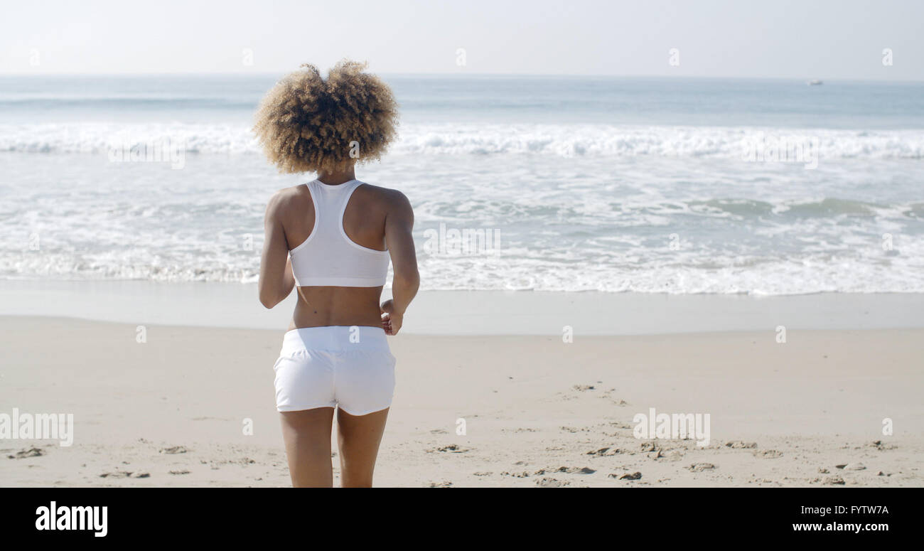 Donna jogging sulla spiaggia Foto Stock