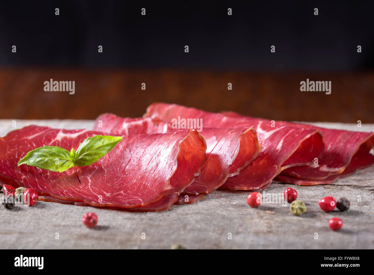 Carne di manzo affumicato fette di carne su sfondo rustico Foto Stock