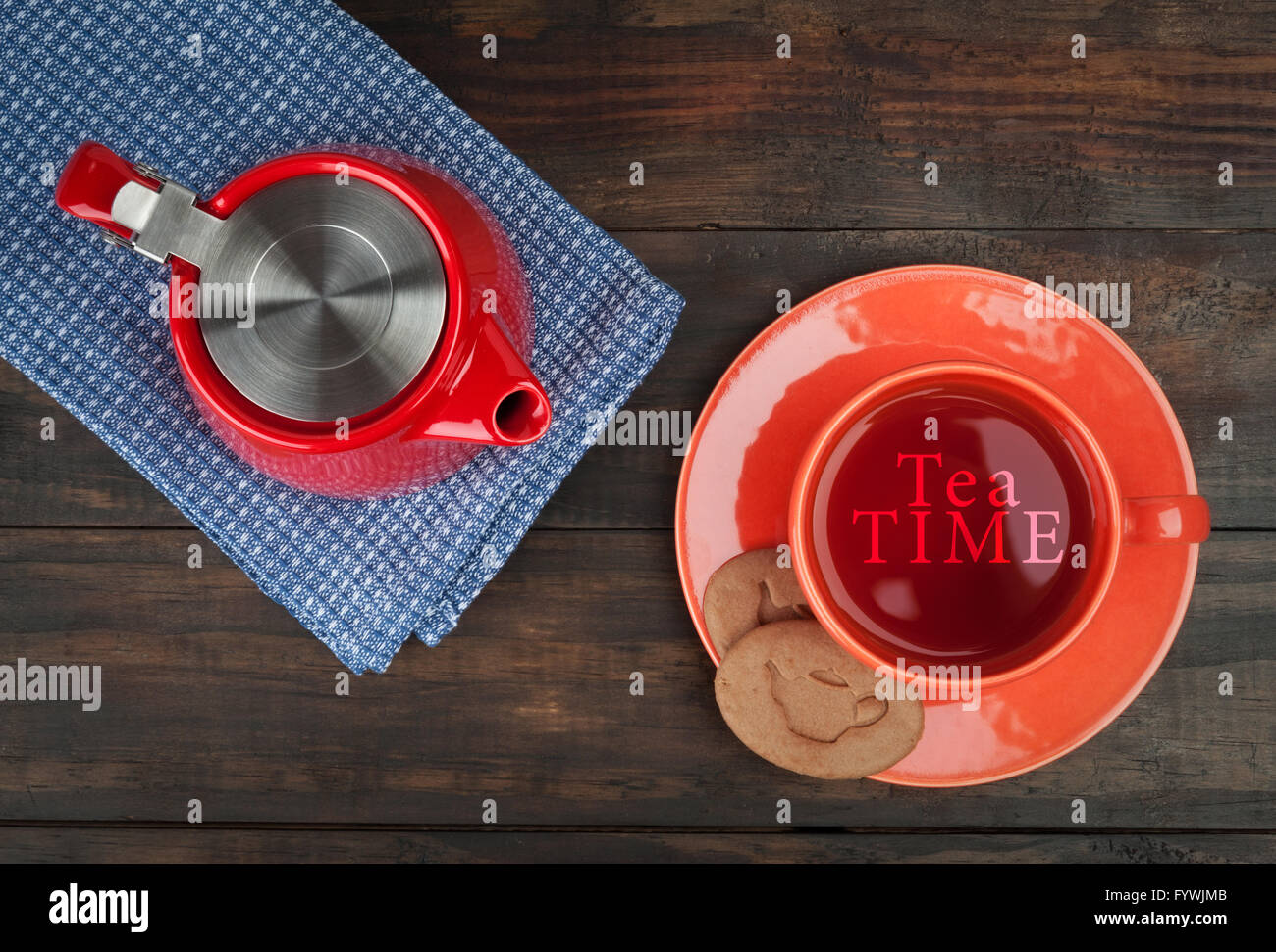 Tea time composizione con leggere teiera e tazzina arancione con i cookie sul tavolo di legno. Vista da sopra con copia spazio. Foto Stock
