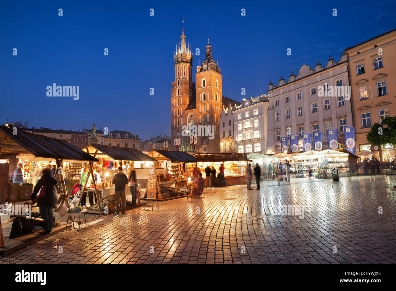 La Polonia, Cracovia, la Città Vecchia di notte, holiday bazaar sorge, cabine, bancarelle sulla piazza principale del mercato e St Mary Basilica (Mariacki C Foto Stock