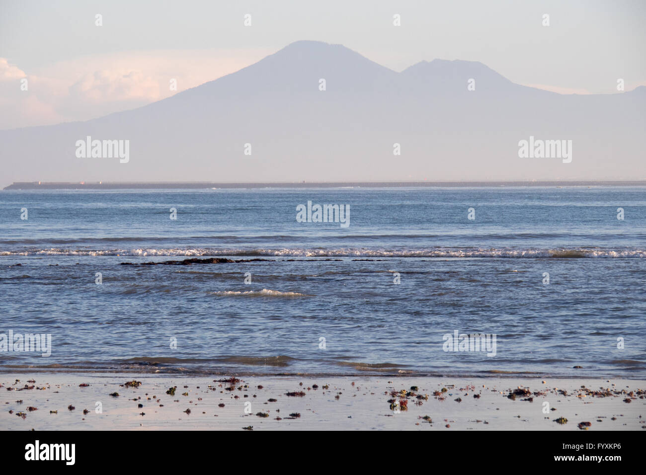 La baia di Jimbaran, Bali, nelle prime ore del mattino con le montagne e l'aeroporto di Bali in pista la distanza. Foto Stock