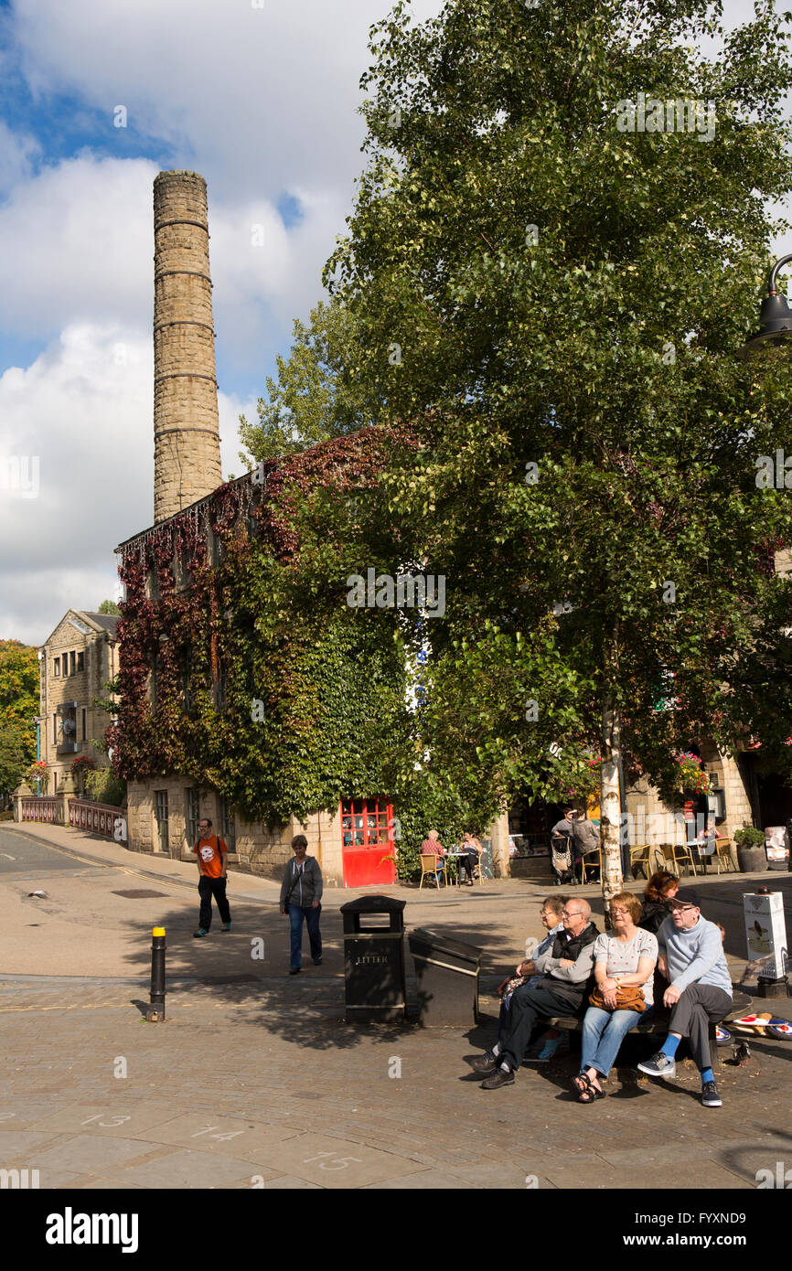 Regno Unito, Inghilterra, Yorkshire, Calderdale, Hebden Bridge, St Georges Square, visitatori sat sotto il camino del mulino Foto Stock