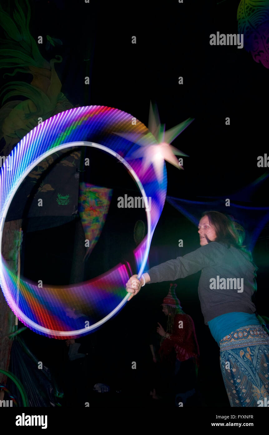 Donna con led psichedelici hula hoop al festival psytrance Foto Stock