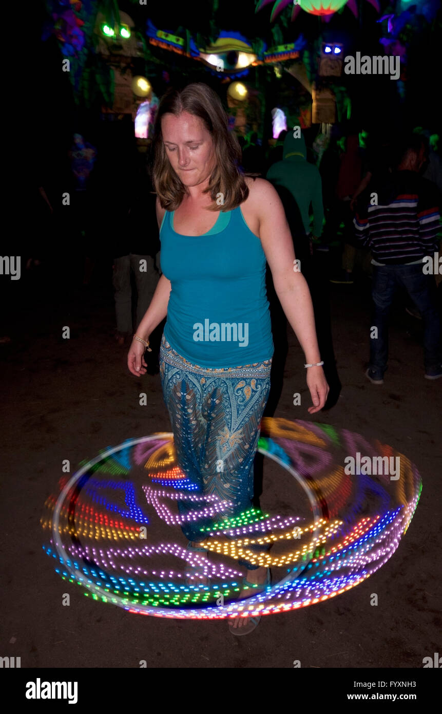 Donna con led psichedelici hula hoop al festival psytrance Foto Stock