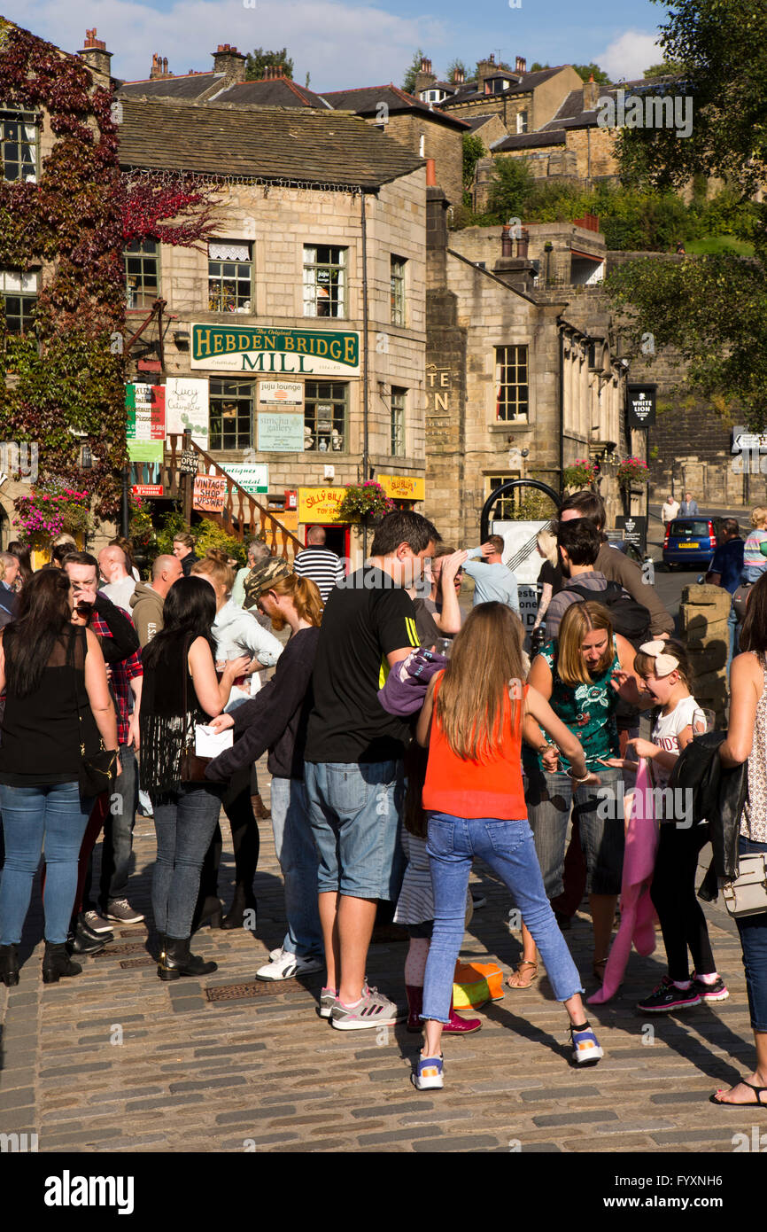 Regno Unito, Inghilterra, Yorkshire, Calderdale, Hebden Bridge, Bridge, porta i visitatori in St Georges Square godendo del sole Foto Stock