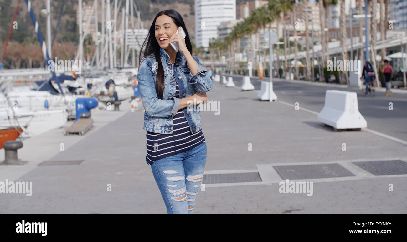 Giovane donna in chat sul suo telefono in strada Foto Stock