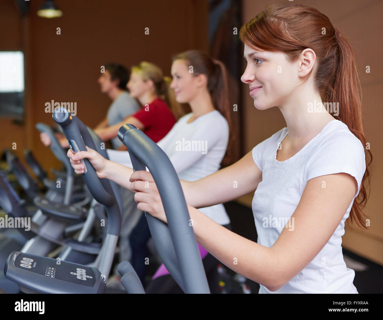 Giovane donna esercita su un crosstrainer nel centro fitness Foto Stock