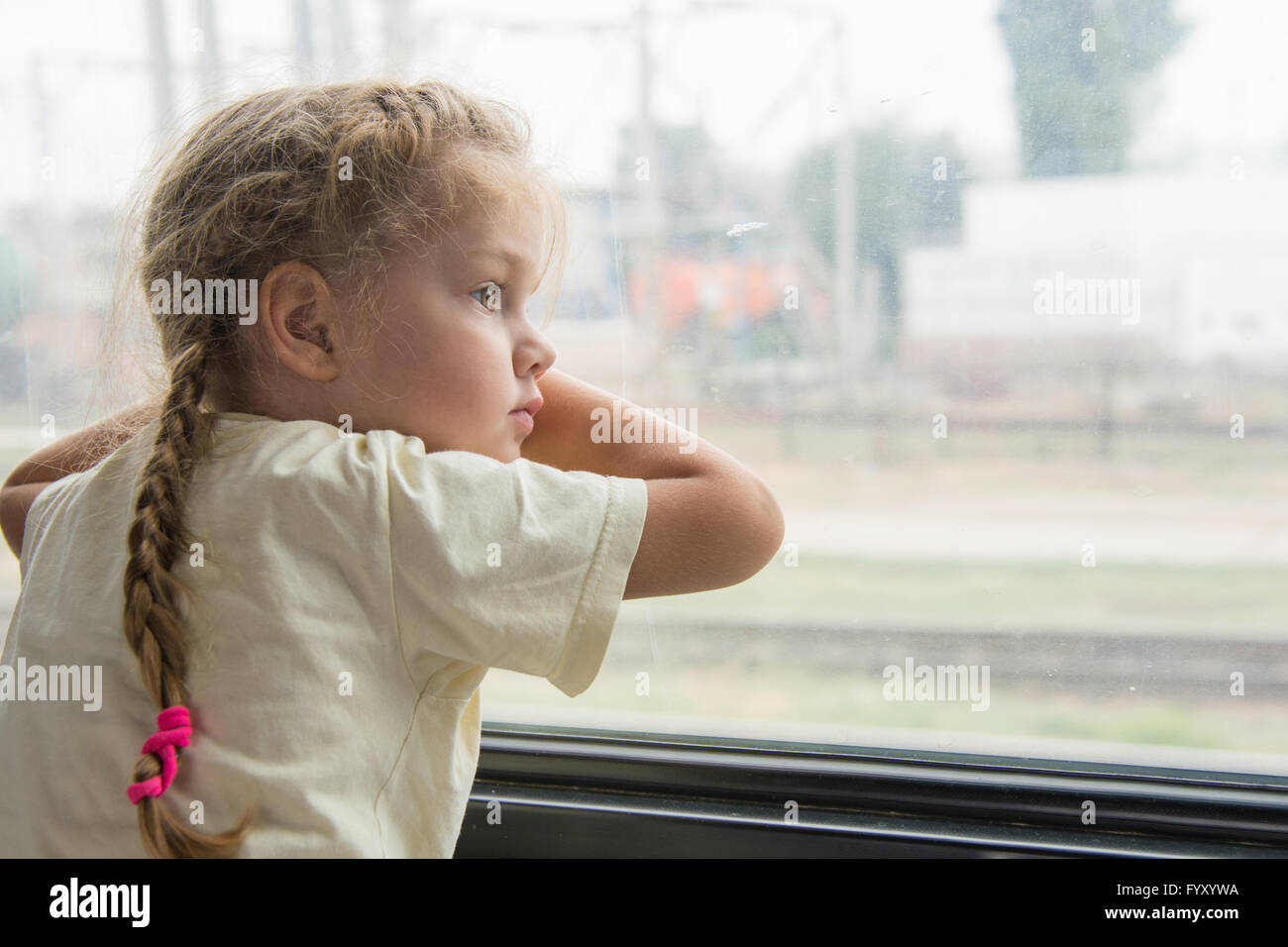 Ragazza con angoscia e tristezza guarda fuori dalla finestra della carrozza del treno Foto Stock