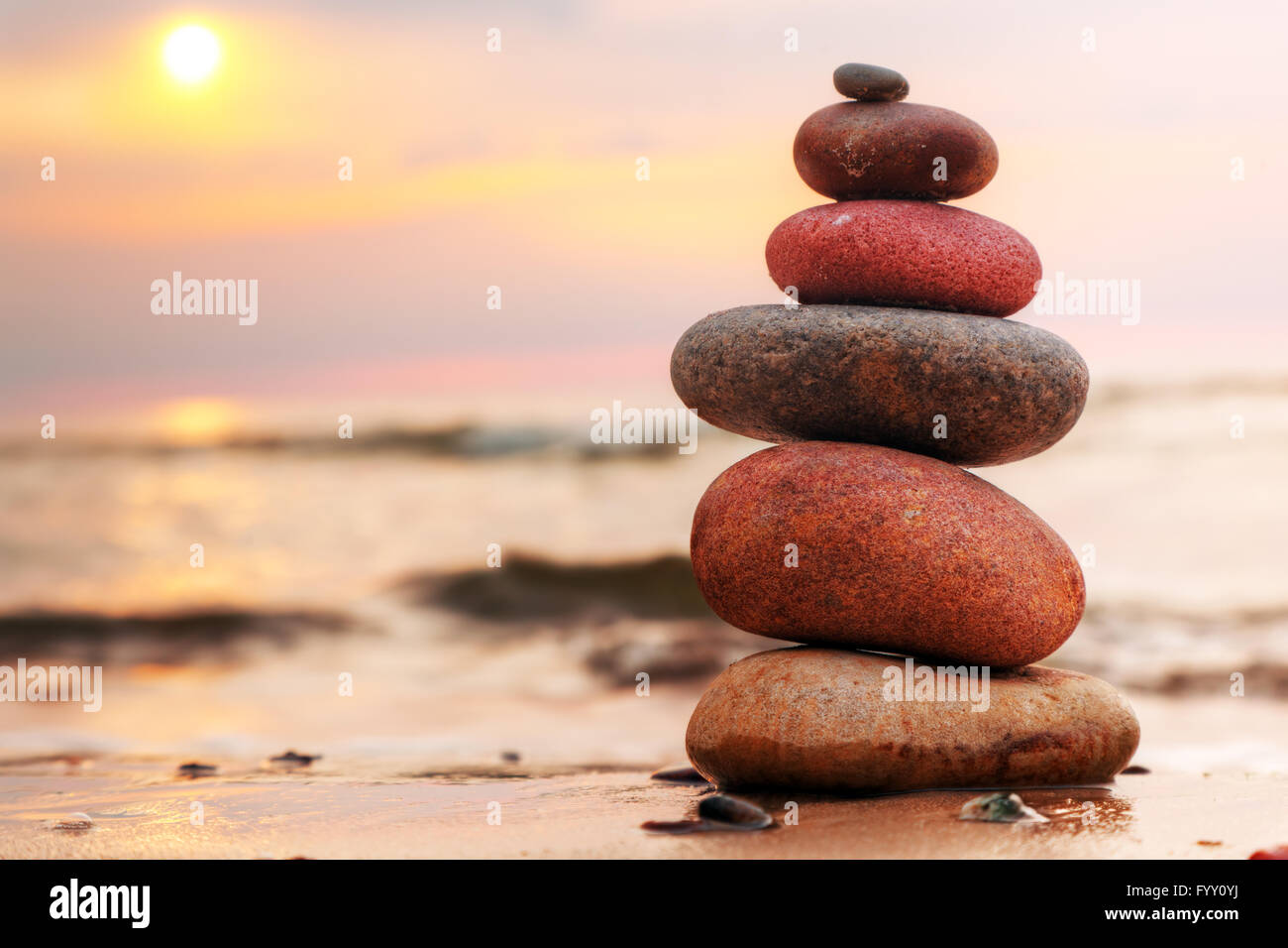 Piramide di pietre sulla sabbia che simboleggia lo zen Foto Stock