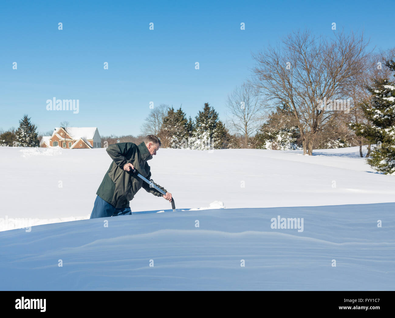 Senior adulto uomo cercando di scavare la guida sulla neve Foto Stock