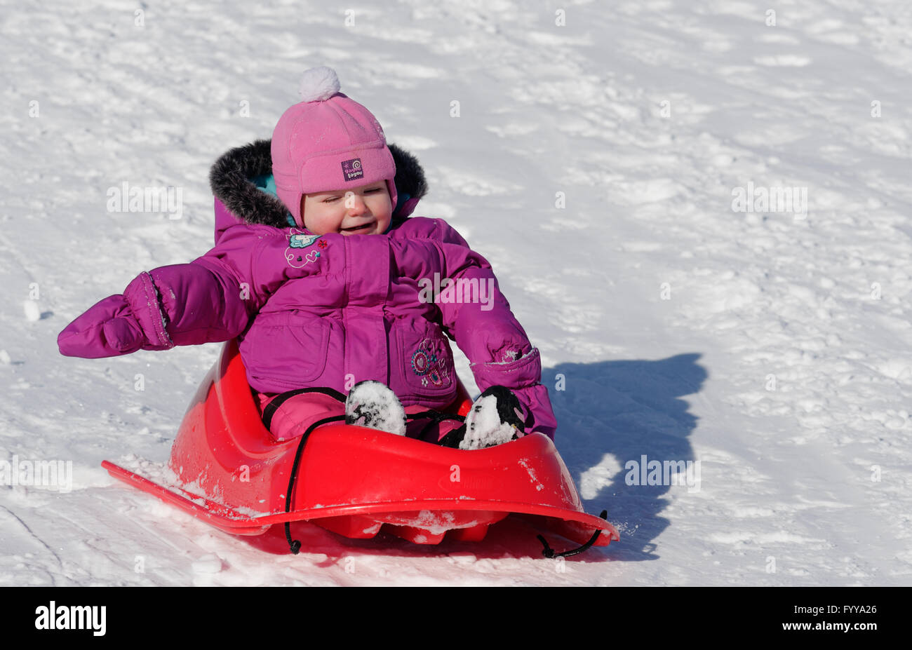 Ridere 2 anno vecchia ragazza in una slitta Foto Stock