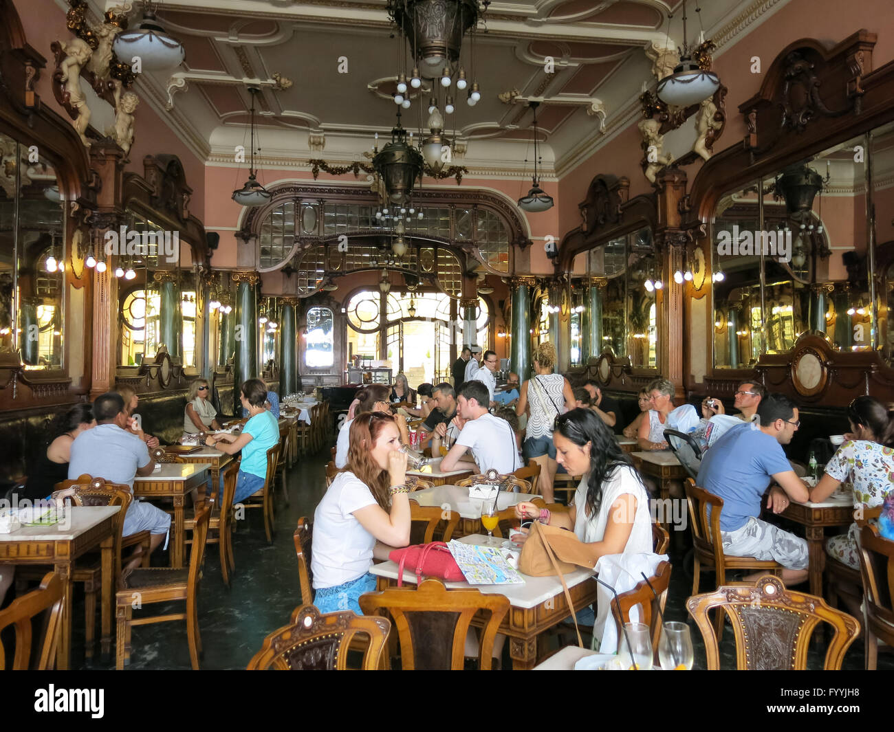 Le persone che si godono e avente le bevande all'interno del famoso Cafe maestoso sulla Rua Santa Catarina a Porto, Portogallo Foto Stock