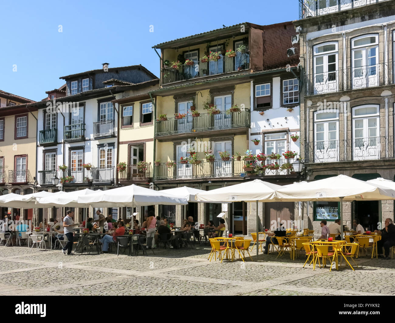 Persone relax sulle caffetterie su Oliveira piazza nel centro storico di Guimaraes, Portogallo Foto Stock