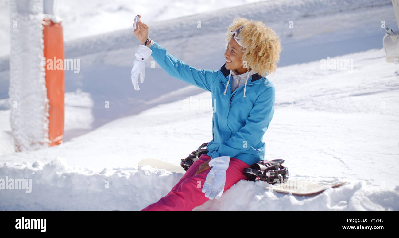 Felice giovane donna posa per un inverno selfie Foto Stock