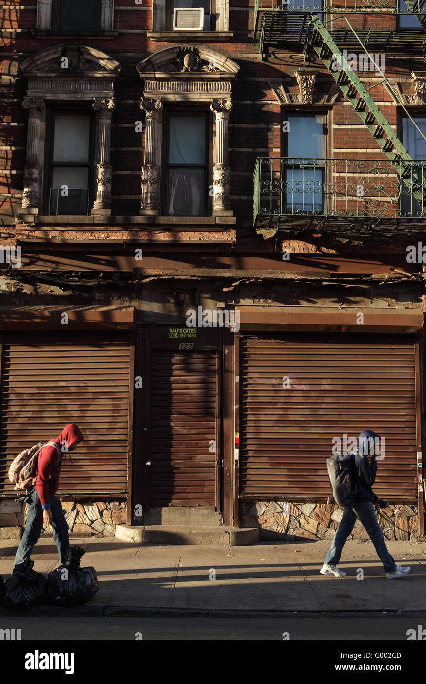 Sul loro modo di scuola, i due ragazzi a piedi passato un negozio chiuso in NYC. Mattone antico casamento su Rivington Street, Lower East Sid Foto Stock